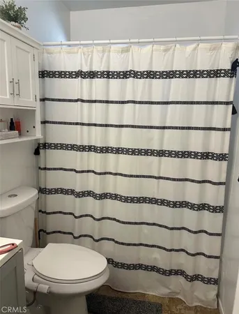 a bathroom with a toilet and a shower curtain