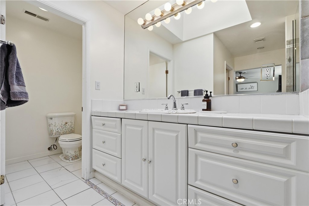 10808 Des Moines Avenue Porter Ranch, CA 91326 - Photo 23 of 39 a bathroom with a toilet sink and mirror