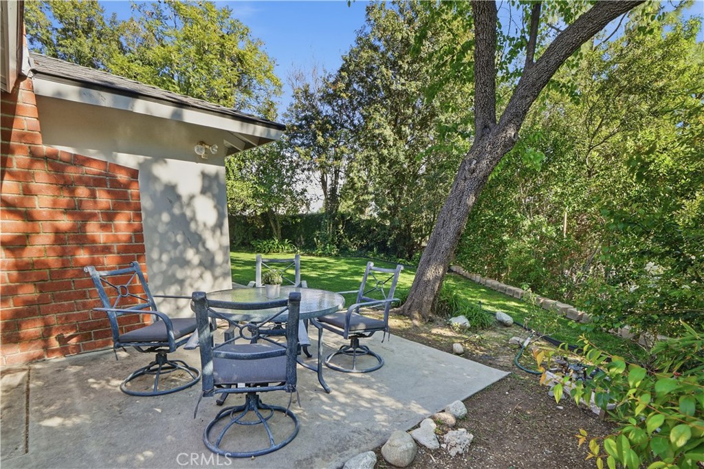 10808 Des Moines Avenue Porter Ranch, CA 91326 - Photo 31 of 39 a view of patio with table and chairs potted plants and a large tree