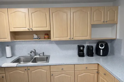 a kitchen with white cabinets and sink