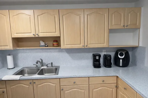 a kitchen with white cabinets and sink