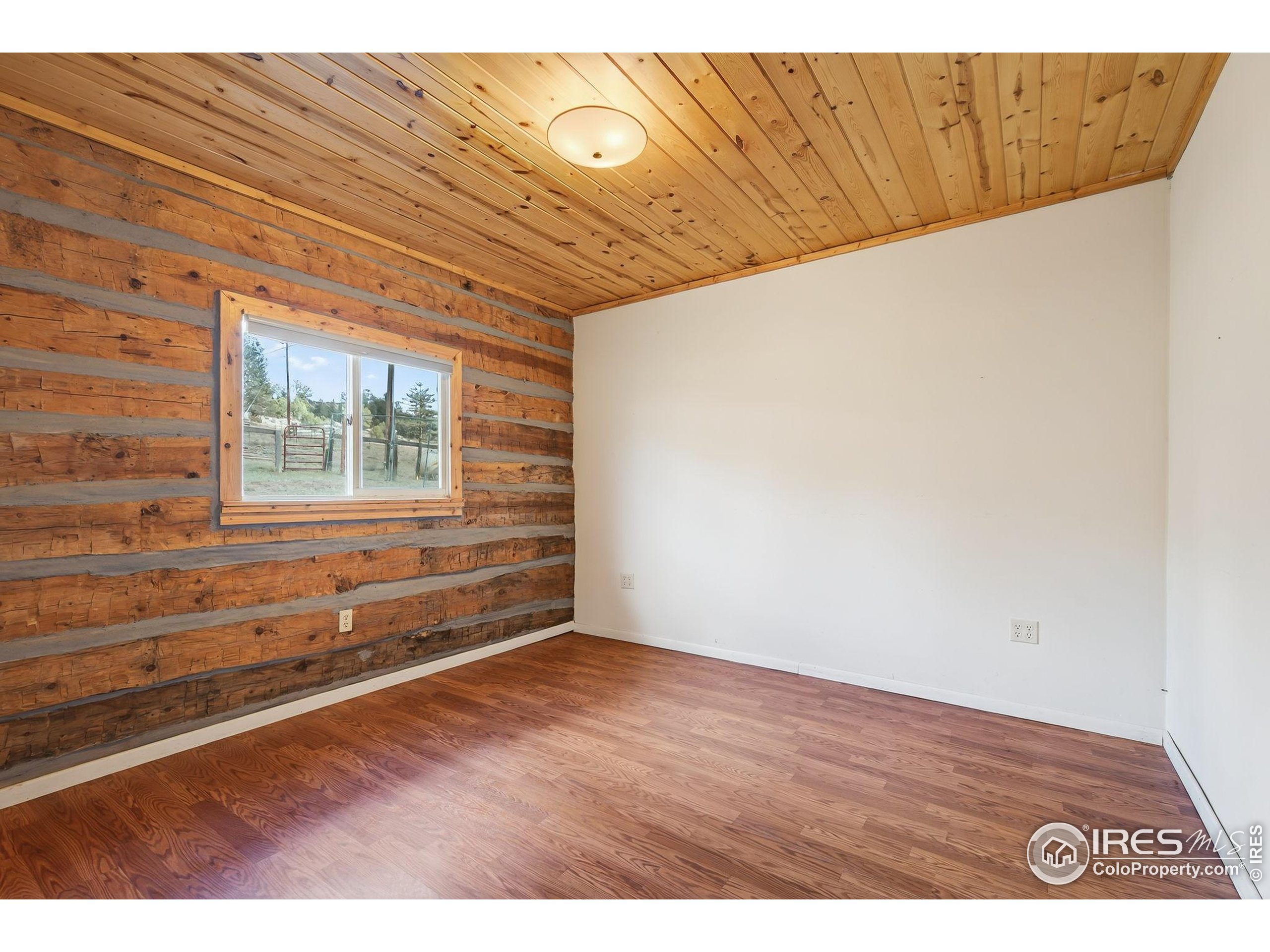 2848 Slater Creek Road Guffey, CO 80820 - Photo 11 of 50 a view of an empty room with wooden floor and a window
