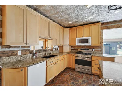 a kitchen with stainless steel appliances granite countertop a sink a stove and cabinets