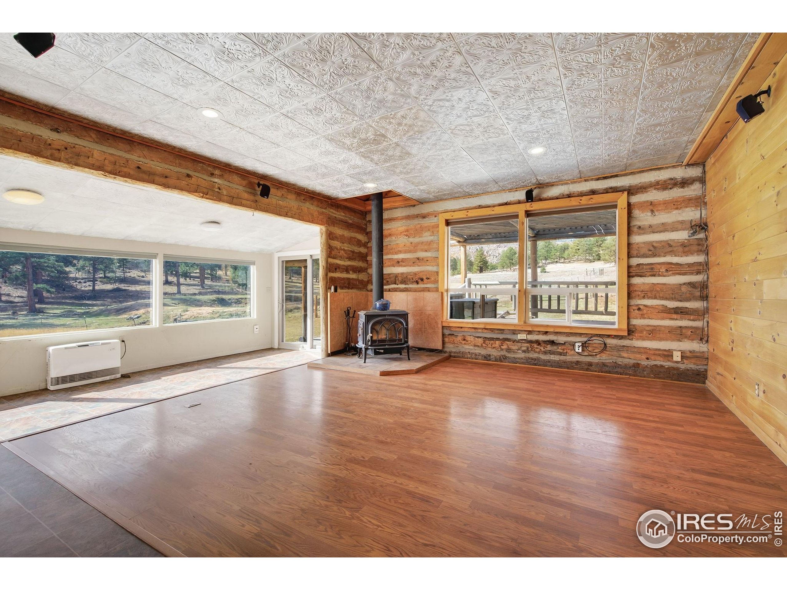 2848 Slater Creek Road Guffey, CO 80820 - Photo 9 of 50 a view of an empty room with a window and wooden floor