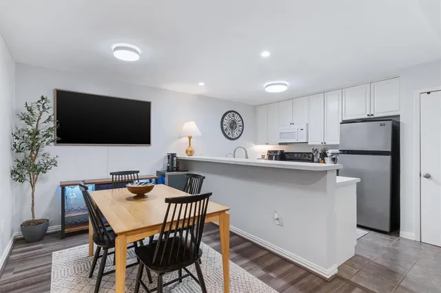 a kitchen with stainless steel appliances a microwave a stove a table and chairs