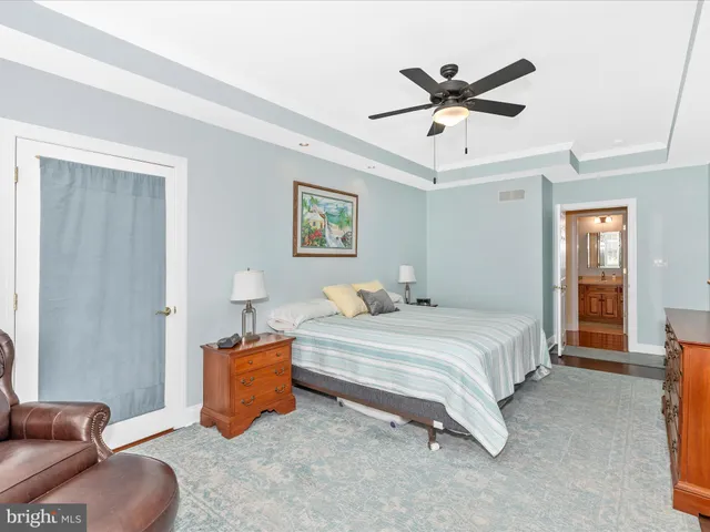 a spacious bedroom with a bed and ceiling fan