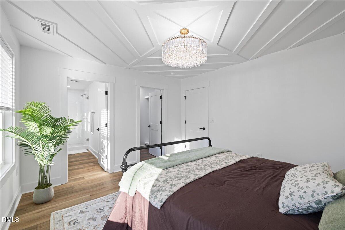 617 North 3rd Street Mebane, NC 27302 - Photo 29 of 50 a bedroom with bed and a chandelier