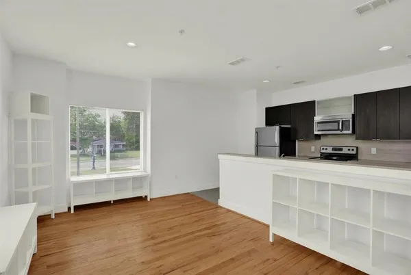 a kitchen with stainless steel appliances a stove top oven a sink a refrigerator a window