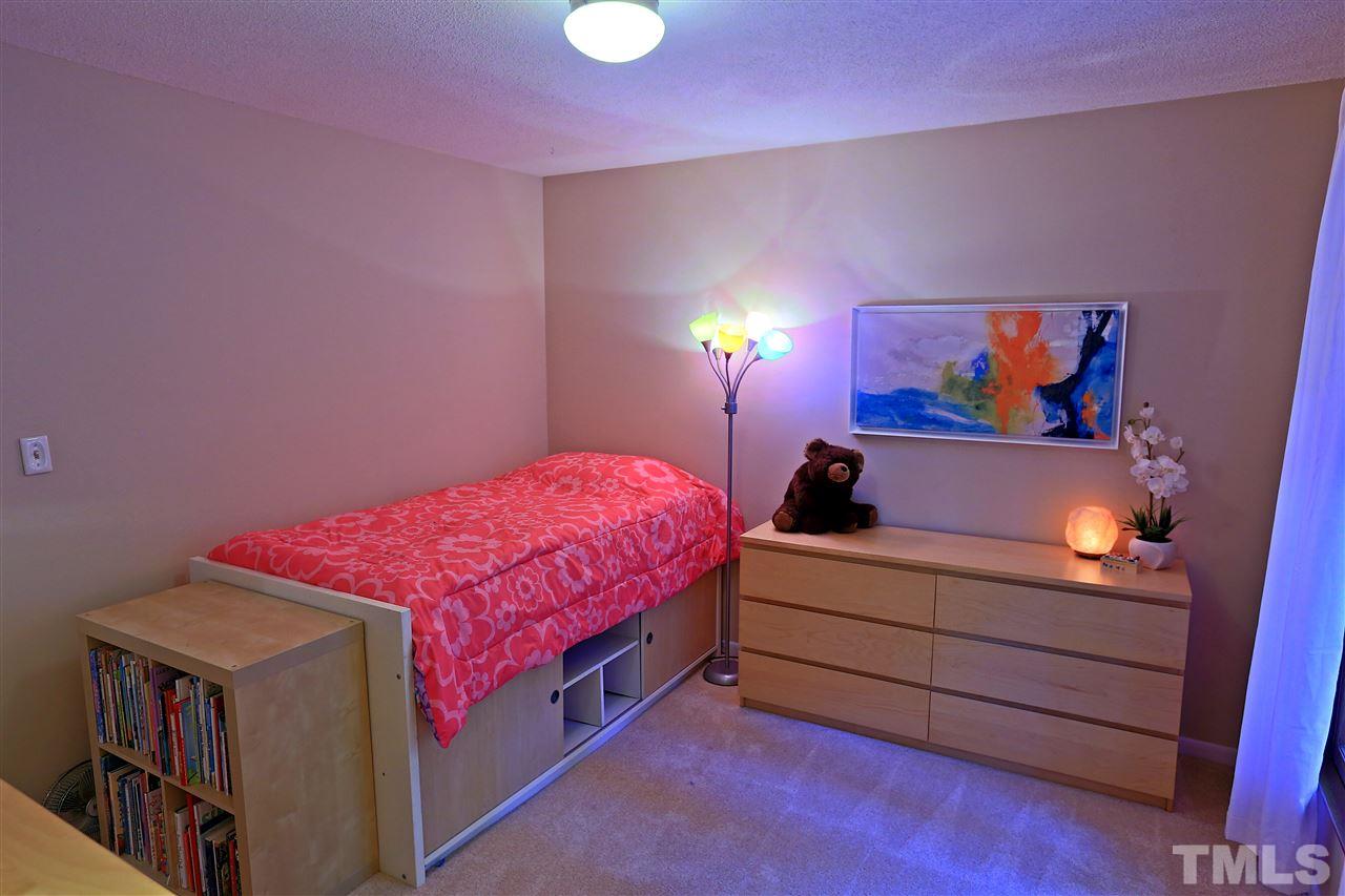 4921 Oak Park Road Raleigh, NC 27612 - Photo 14 of 25 a spacious bedroom with a bed and a window