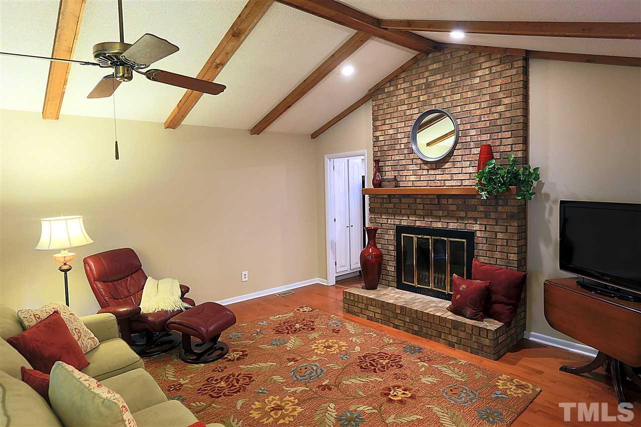 4921 Oak Park Road Raleigh, NC 27612 - Photo 3 of 25 a living room with furniture a flat screen tv and a fireplace
