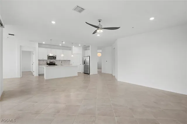 a view of a kitchen with a refrigerator and wooden floor