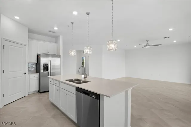a kitchen with a sink chandelier and refrigerator