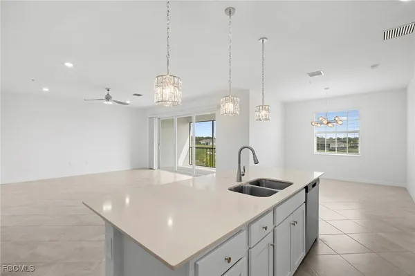 a kitchen with kitchen island a sink a counter space and cabinets