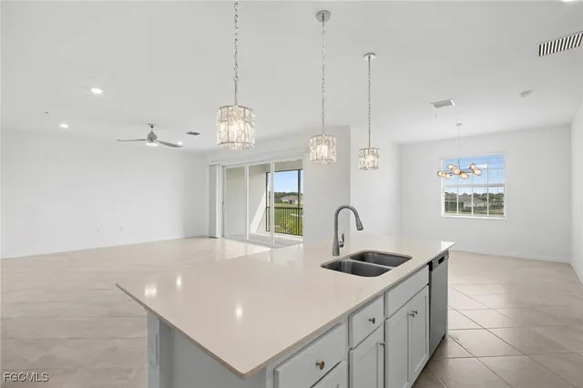 a kitchen with kitchen island a sink a counter space and cabinets