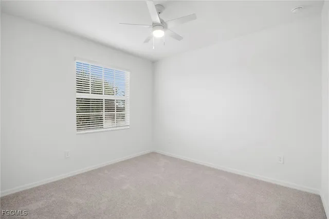 an empty room with a ceiling fan and a window