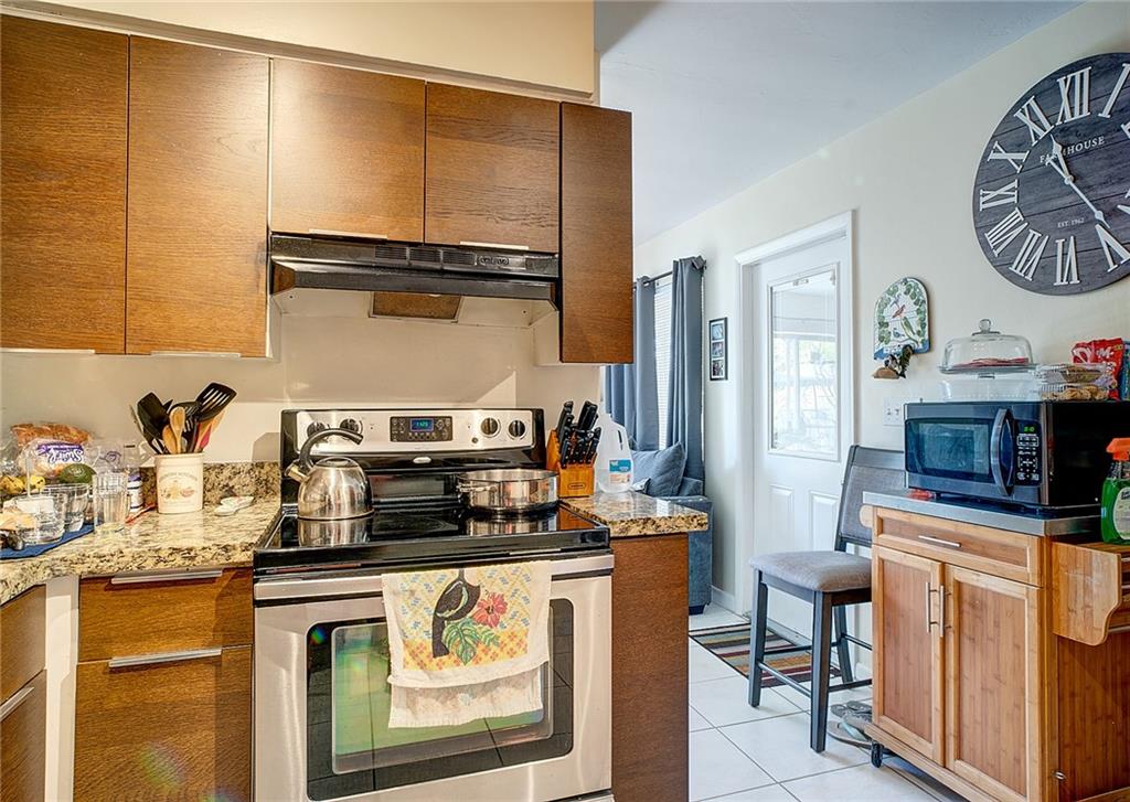 3860 Northeast 23rd Avenue Lighthouse Point, FL 33064 - Photo 16 of 33 a kitchen with stainless steel appliances a stove a sink and a refrigerator with wooden floor