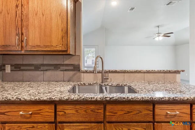 a kitchen with granite countertop a sink and cabinets