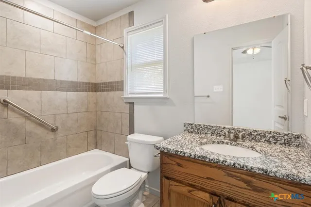 a bathroom with a granite countertop toilet a sink and a mirror