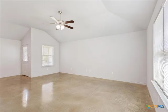 an empty room with windows and fan