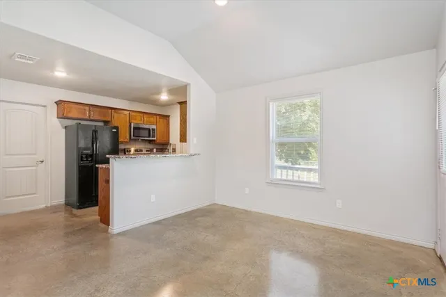 a view of a kitchen with a refrigerator a microwave and a sink