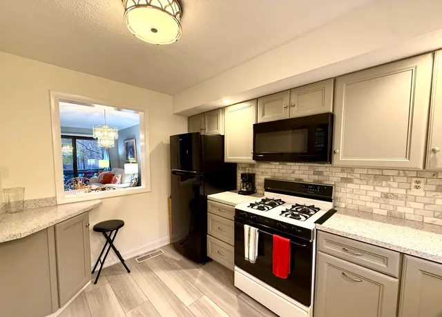 a kitchen with stainless steel appliances a stove refrigerator and microwave