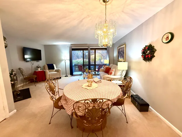 a view of a dining room with furniture and a chandelier