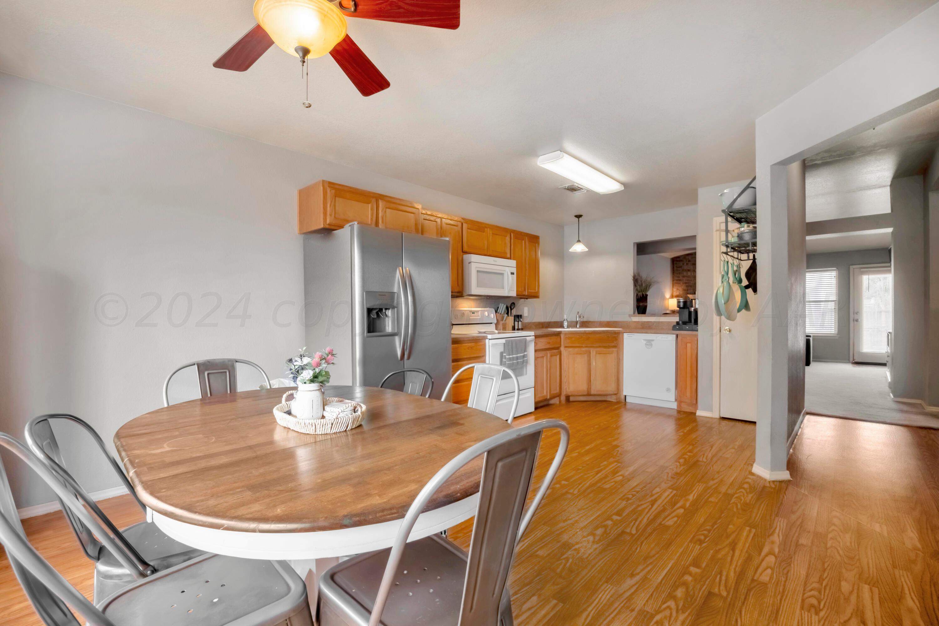 4902 Capulin Lane Amarillo, TX 79110 - Photo 5 of 25 a dining room with furniture a kitchen wooden floor and a chandelier