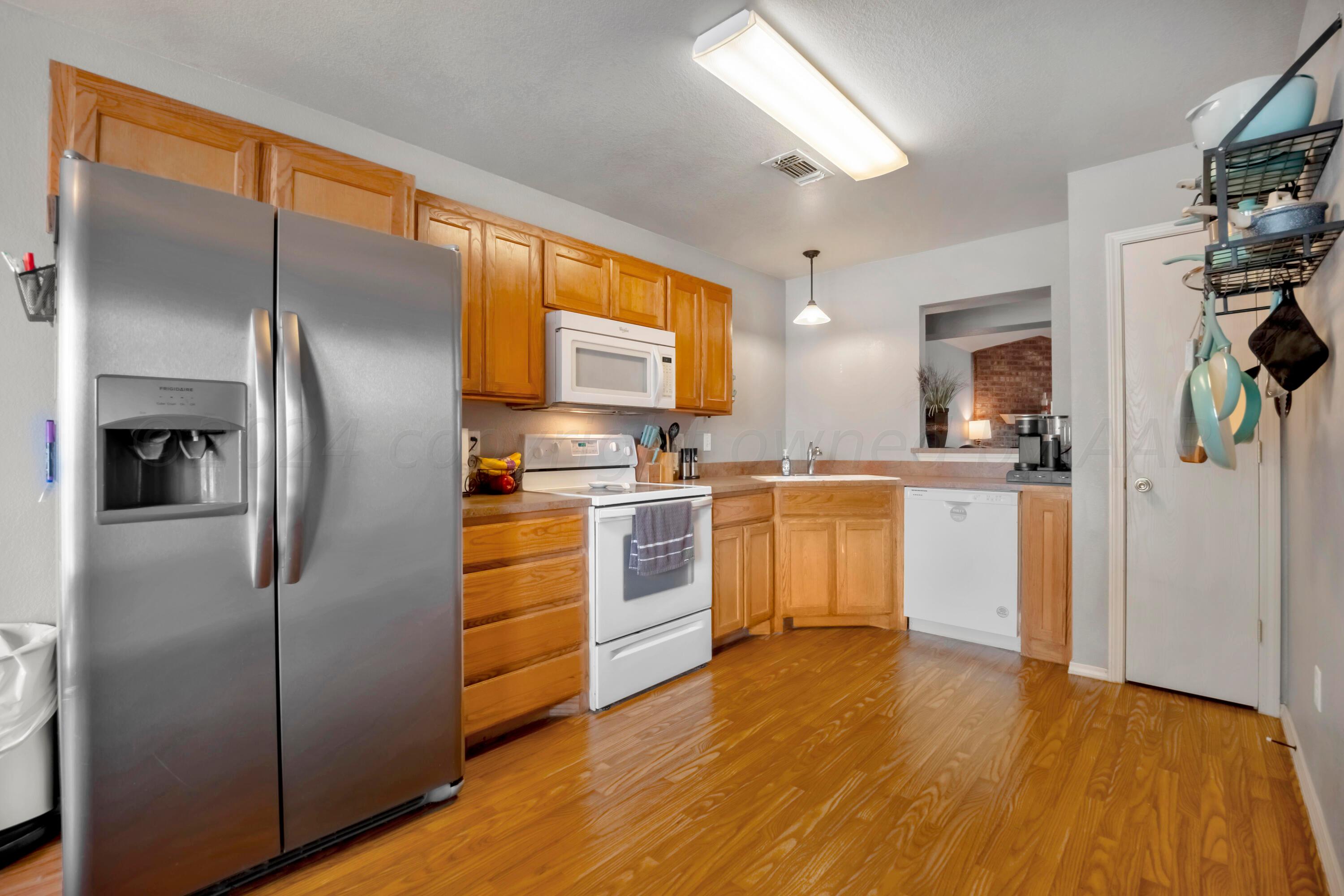 4902 Capulin Lane Amarillo, TX 79110 - Photo 6 of 25 a kitchen with a refrigerator and a sink