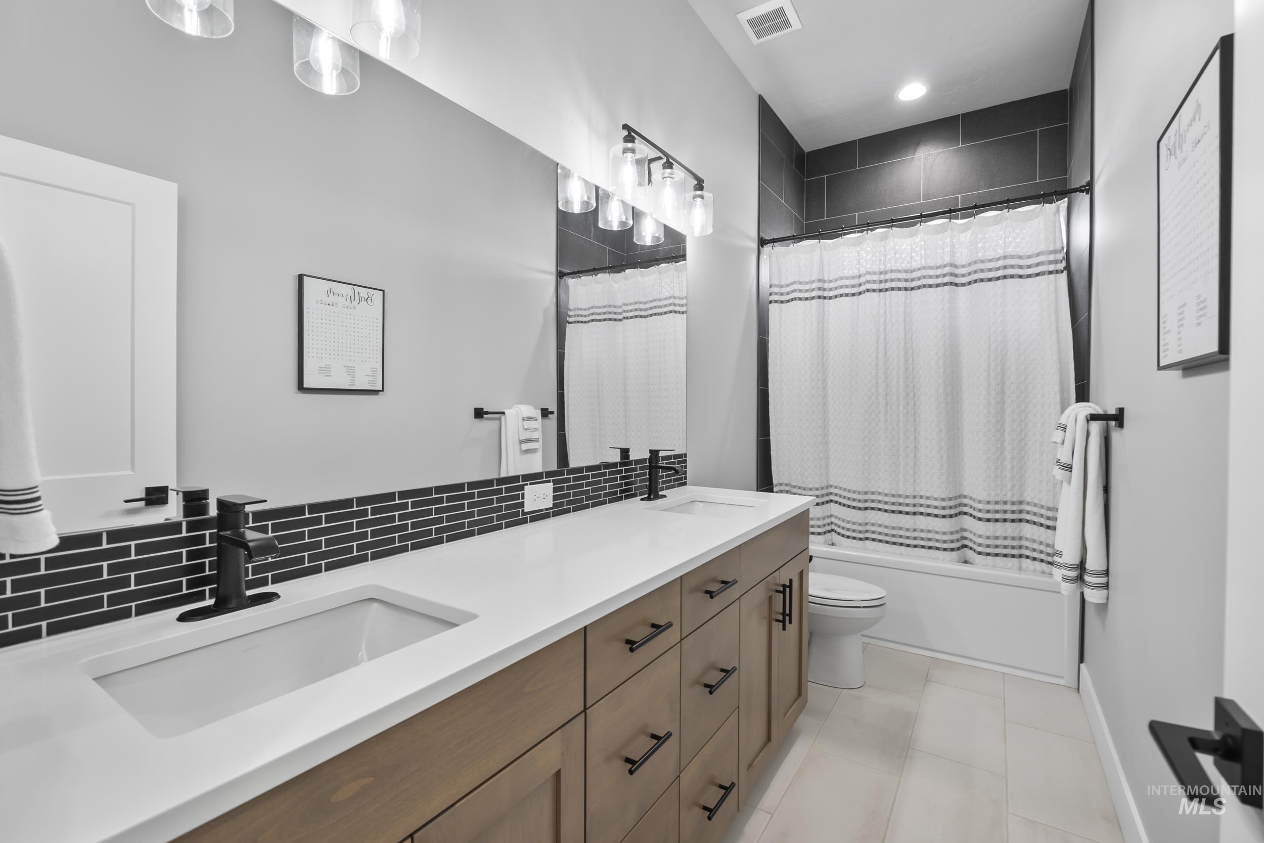 24696 Regal Road Middleton, ID 83644 - Photo 14 of 24 Bathroom with double vanity, shower / bath combo with shower curtain, and decorative backsplash