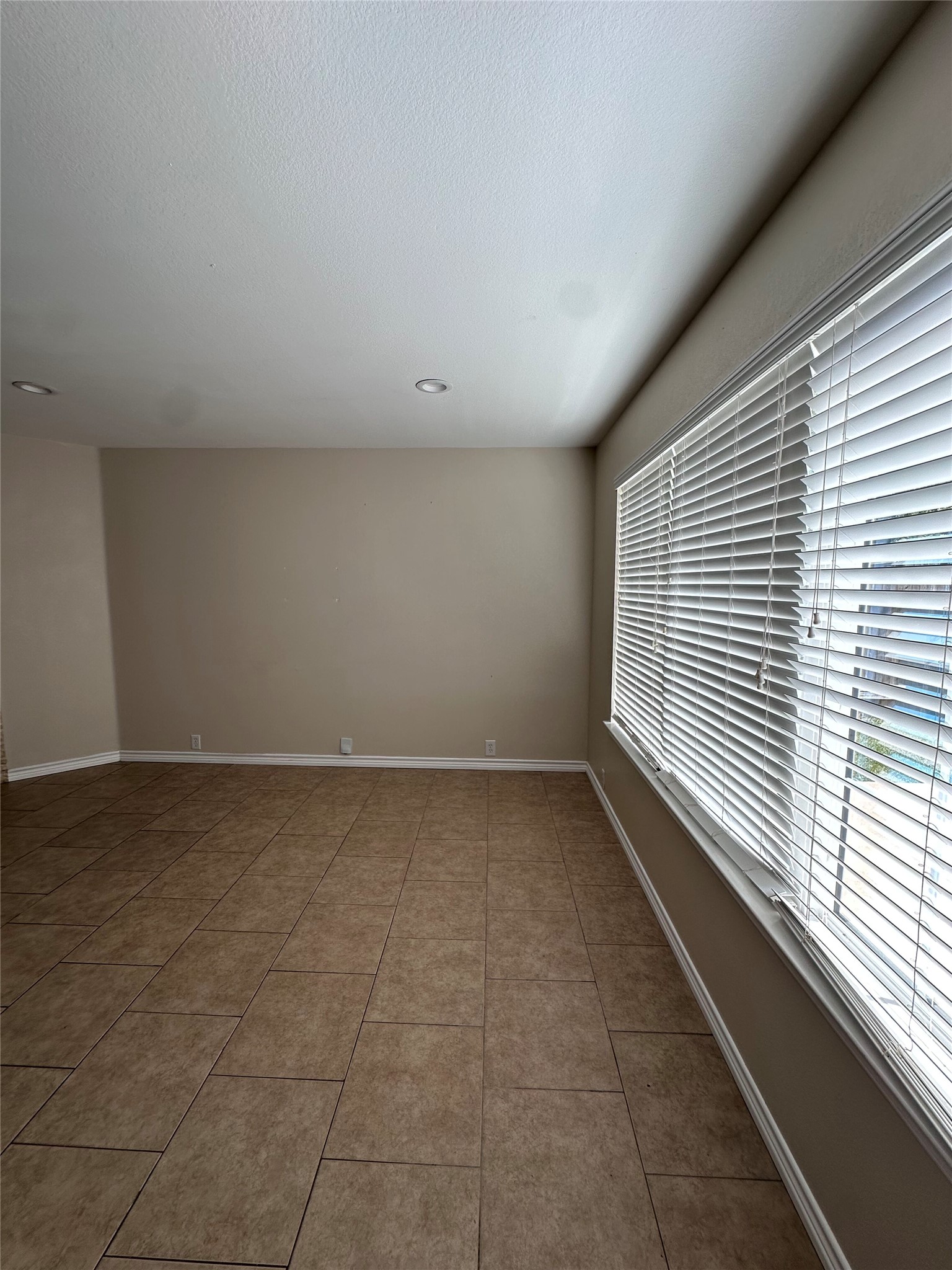 816 Rusk Road Round Rock, TX 78665 - Photo 14 of 29 Recessed lighting illuminates this versatile living space, featuring durable ceramic tile flooring and natural illumination from large windows.