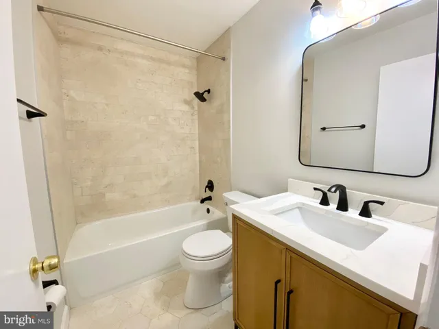 a bathroom with a sink mirror toilet and bathtub