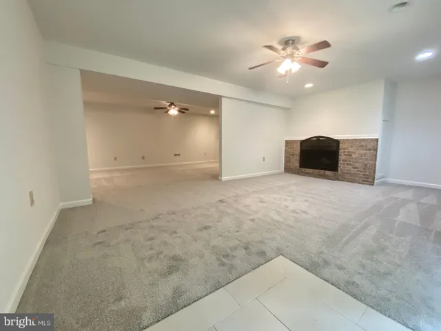 en empty room with windows and ceiling fan