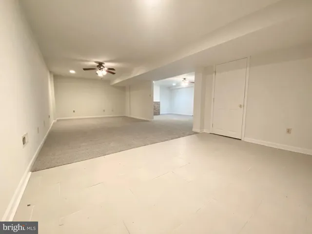an empty room with a ceiling fan and a window