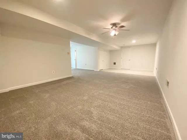 an empty room with a ceiling fan and a window