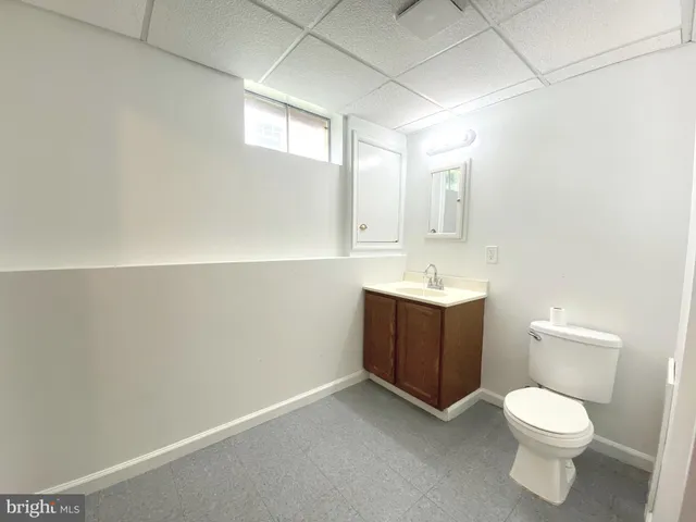 a bathroom with a toilet sink vanity and mirror