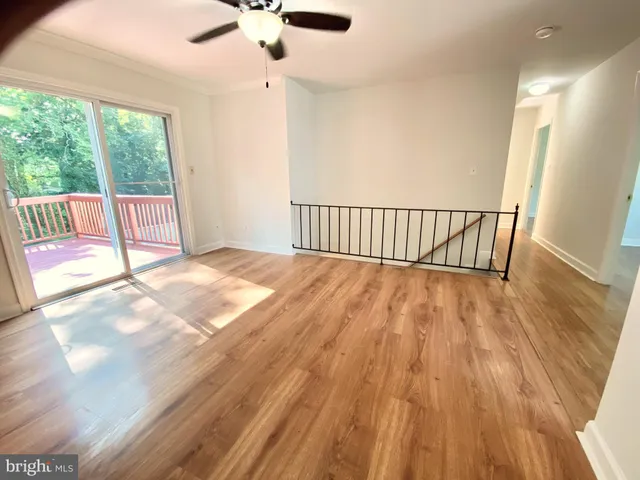 a view of a room with wooden floor fan and windows