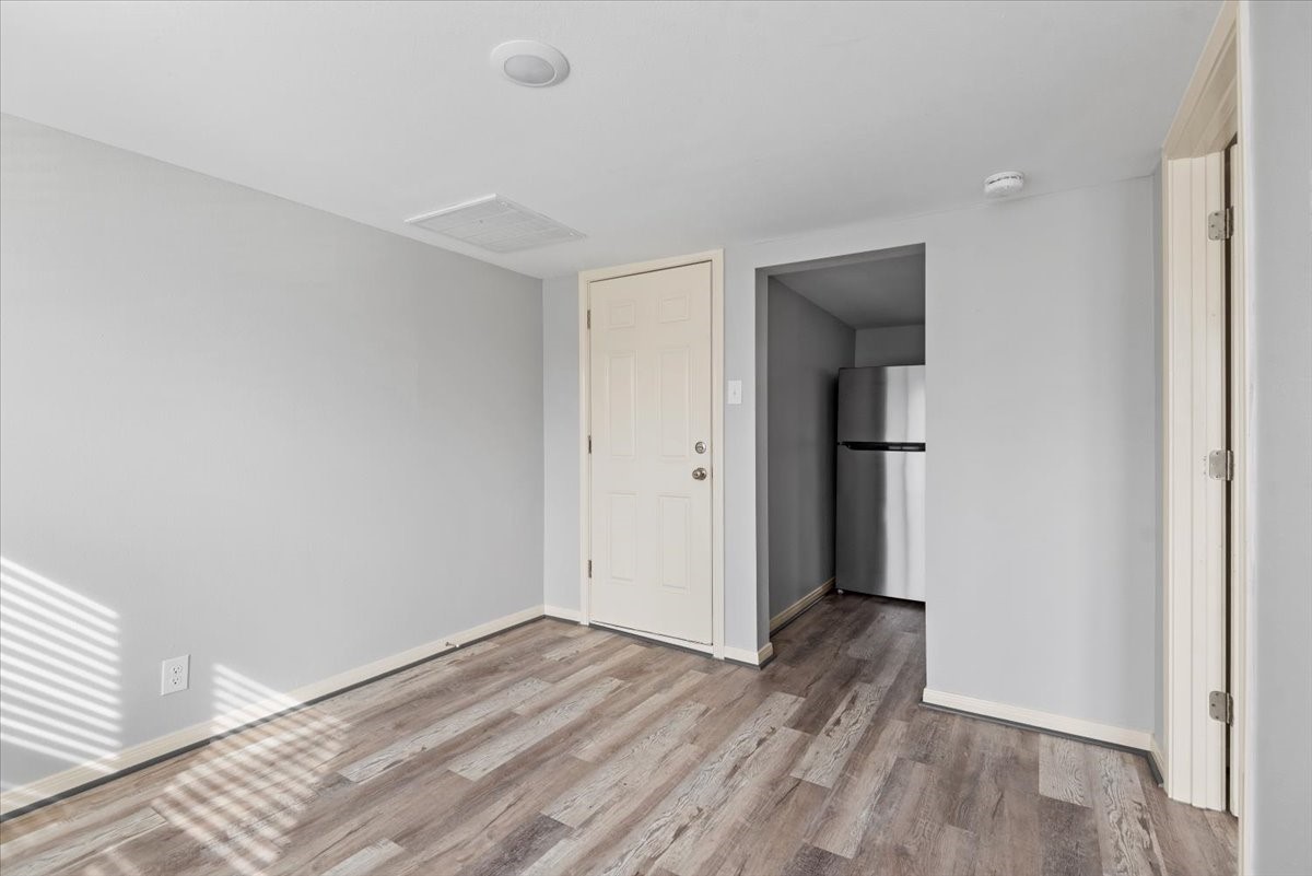 7413 Dallas Street Houston, TX 77011 - Photo 12 of 26 an empty room with wooden floor and entrance