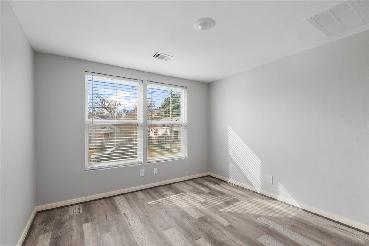 7413 Dallas Street Houston, TX 77011 - Photo 13 of 26 a view of an empty room with wooden floor and a window