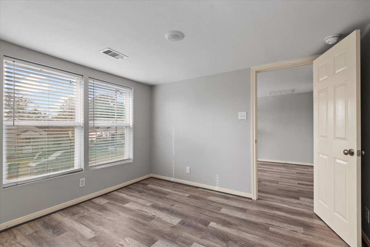 7413 Dallas Street Houston, TX 77011 - Photo 18 of 26 a view of an empty room with wooden floor and a window