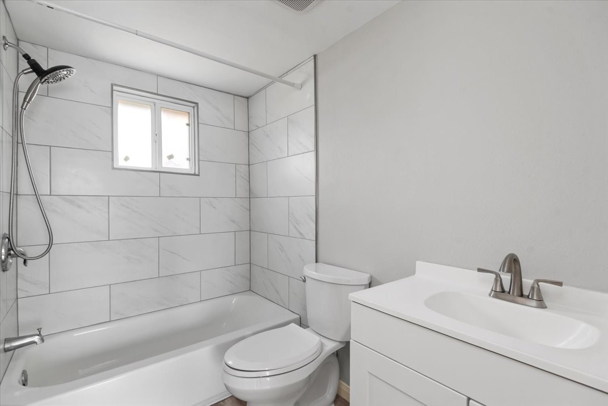 7413 Dallas Street Houston, TX 77011 - Photo 19 of 26 a bathroom with a toilet a sink a mirror and shower