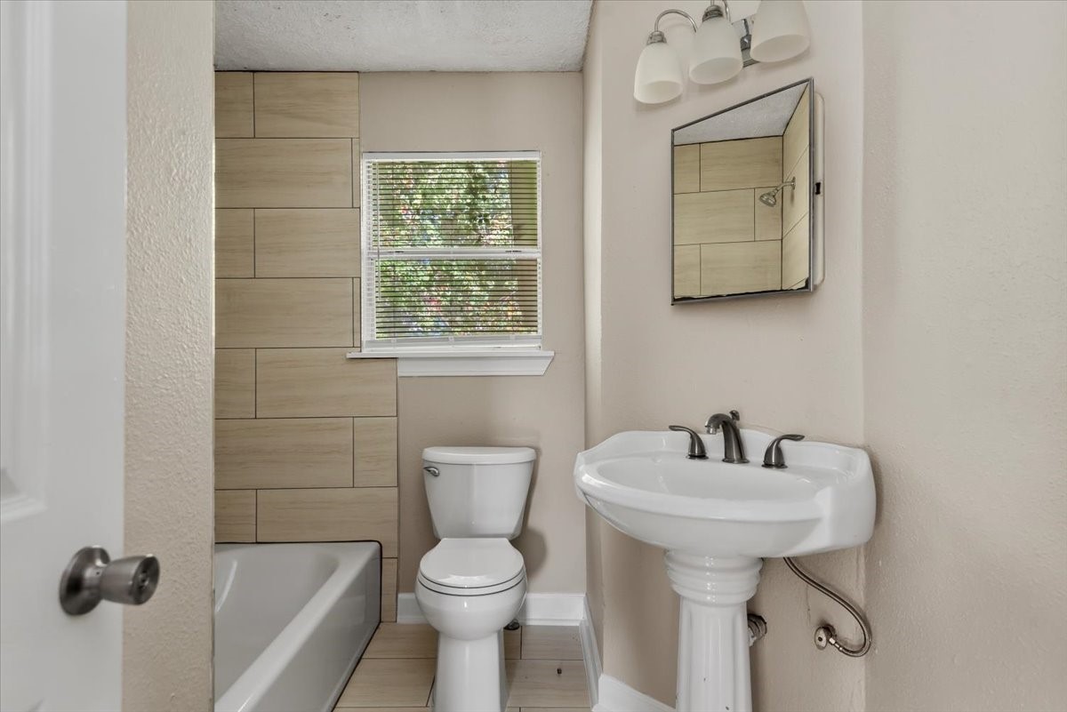 7413 Dallas Street Houston, TX 77011 - Photo 10 of 26 a bathroom with a toilet sink and mirror