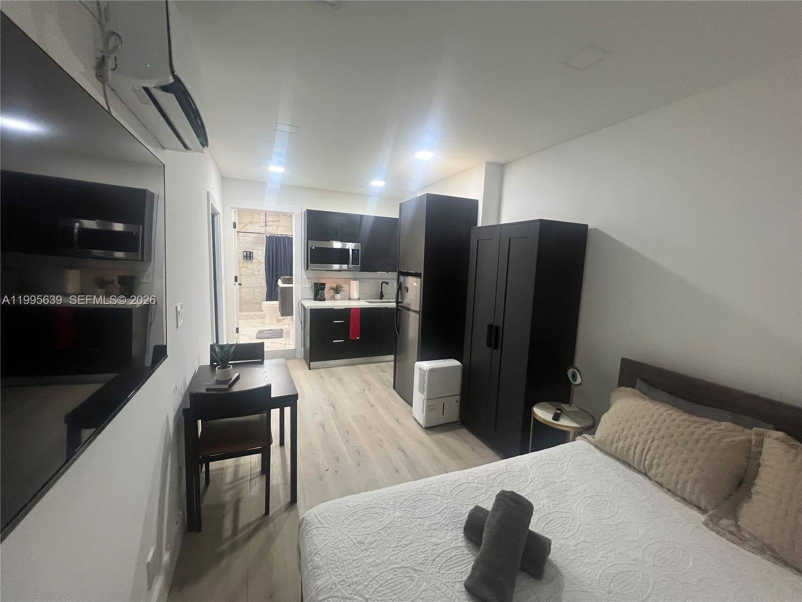 2723 Southwest 13th Street, Unit STUDIO Miami, FL 33135 - Photo 2 of 10 a living room with stainless steel appliances furniture a rug and a view of kitchen