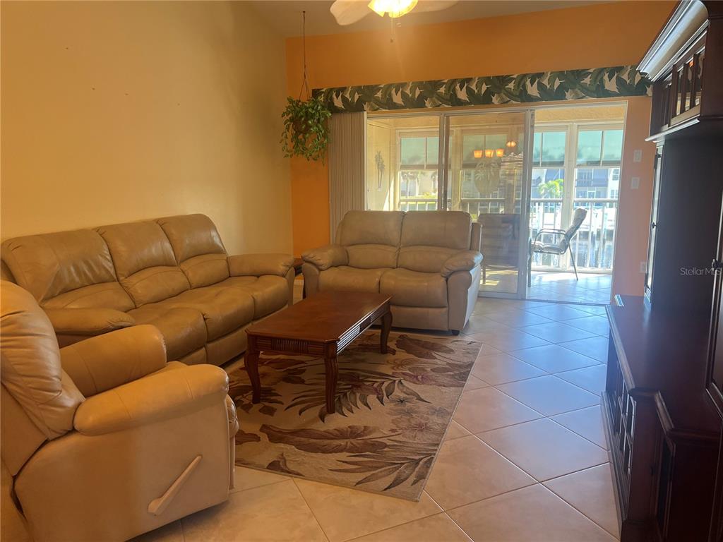 220 Coldeway Drive, Unit 123 Punta Gorda, FL 33950 - Photo 11 of 59 a living room with furniture and a floor to ceiling window