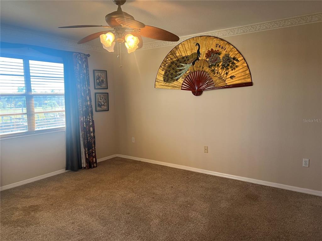 220 Coldeway Drive, Unit 123 Punta Gorda, FL 33950 - Photo 12 of 59 an empty room with windows and a chandelier fan