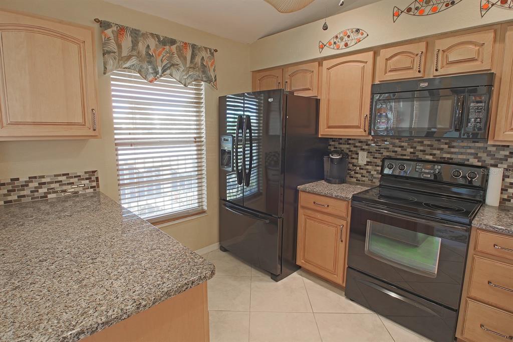 220 Coldeway Drive, Unit 123 Punta Gorda, FL 33950 - Photo 35 of 59 a kitchen with stainless steel appliances granite countertop a sink stove and refrigerator