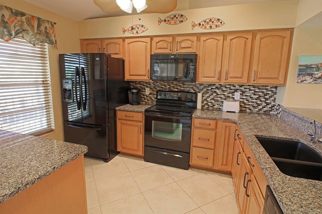 220 Coldeway Drive, Unit 123 Punta Gorda, FL 33950 - Photo 37 of 59 a kitchen with stainless steel appliances granite countertop a stove a sink and a microwave
