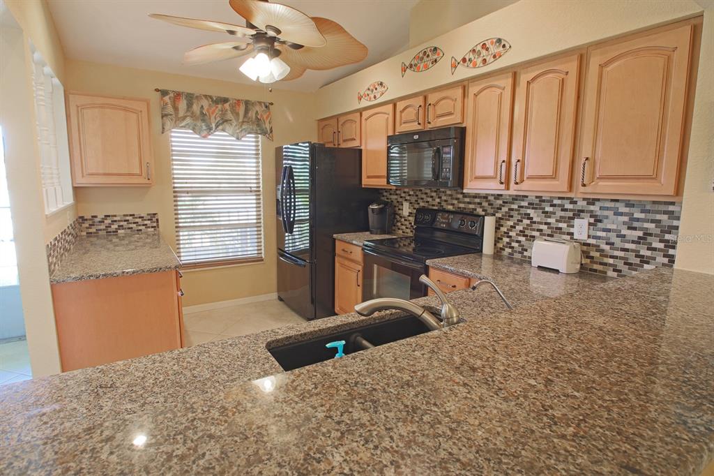 220 Coldeway Drive, Unit 123 Punta Gorda, FL 33950 - Photo 44 of 59 a kitchen with stainless steel appliances kitchen island granite countertop a refrigerator and a sink