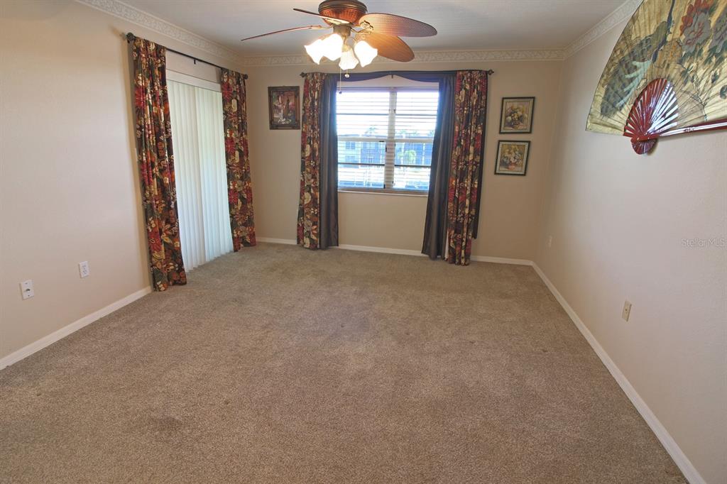 220 Coldeway Drive, Unit 123 Punta Gorda, FL 33950 - Photo 45 of 59 an empty room with windows and chandelier fan