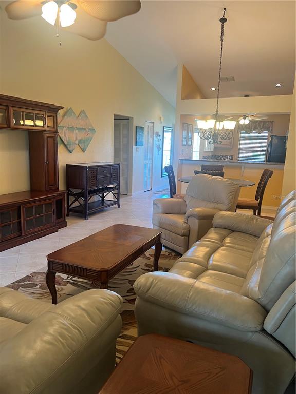 220 Coldeway Drive, Unit 123 Punta Gorda, FL 33950 - Photo 6 of 59 a living room with furniture a chandelier and a flat screen tv