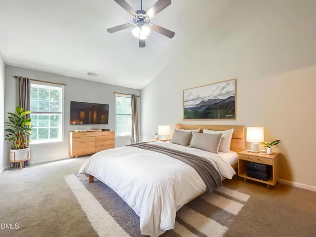 a view of an empty room with a chandelier fan